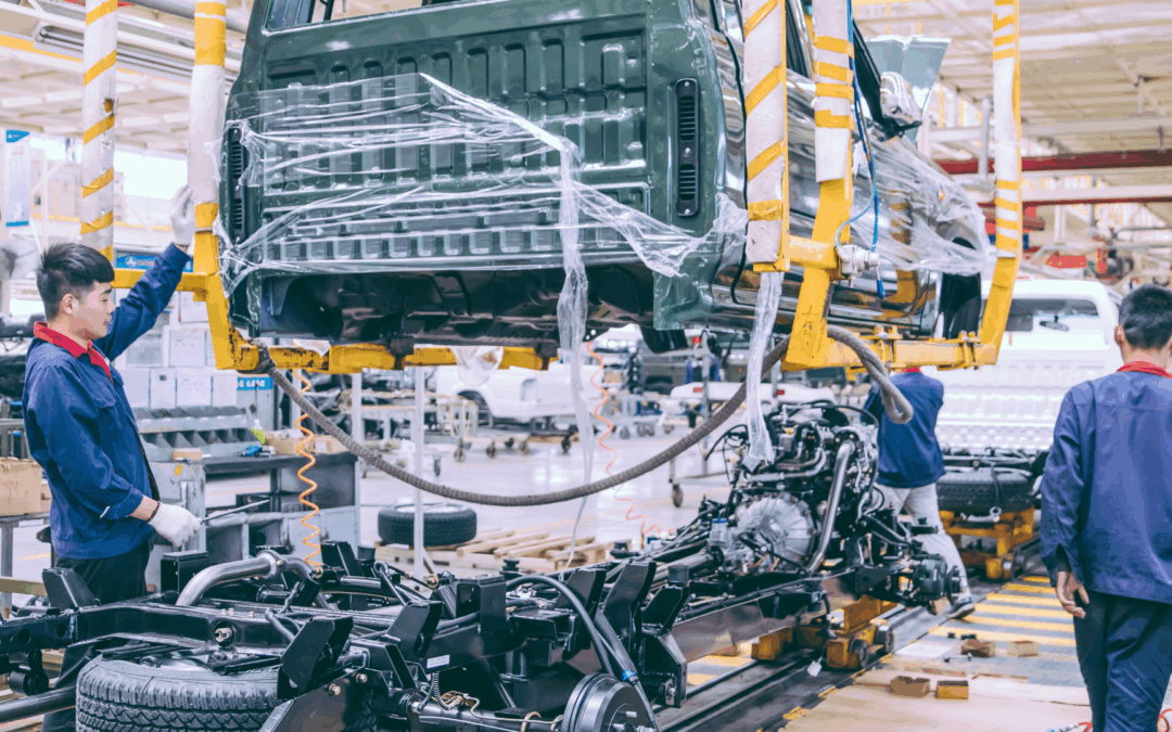 Automotive factory workers assembling a truck on a modern production line to improve efficiency and streamline manufacturing processes.